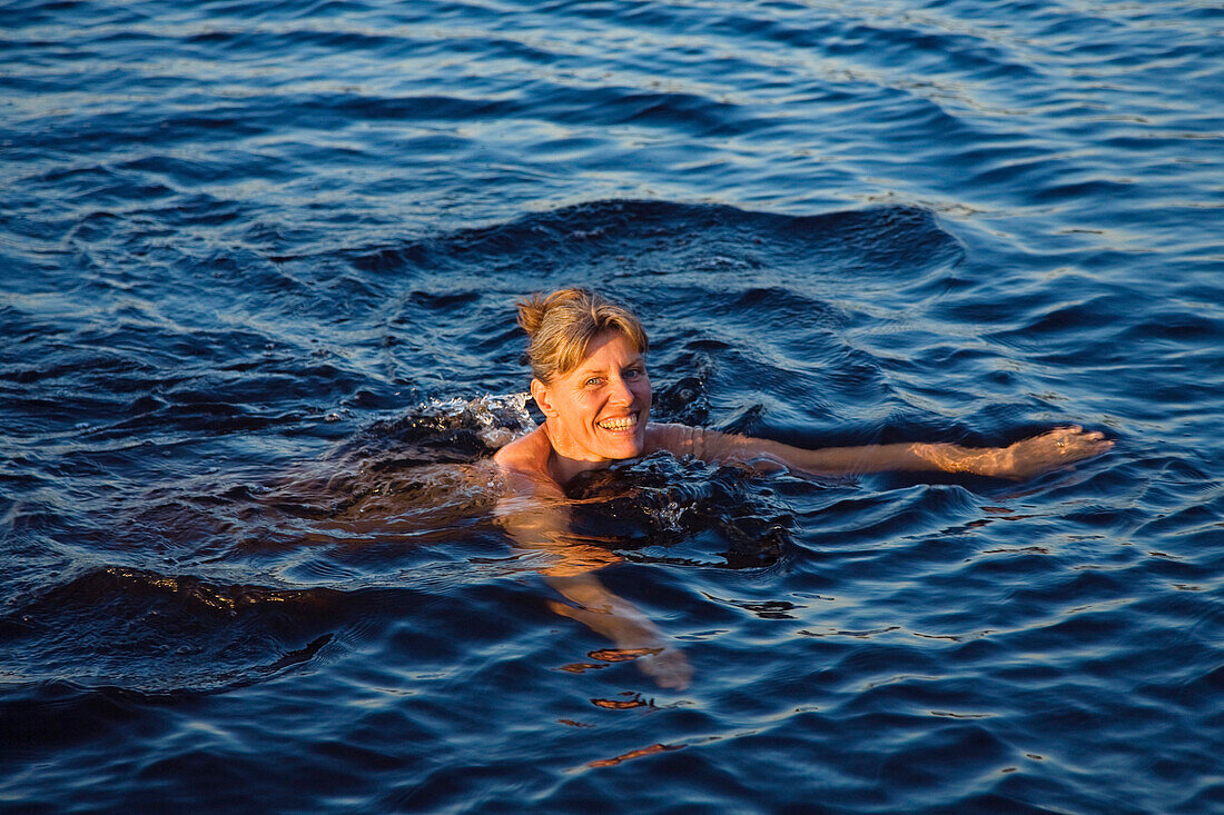 Mature woman swimming in lake Boasjon, Smaland, Sweden