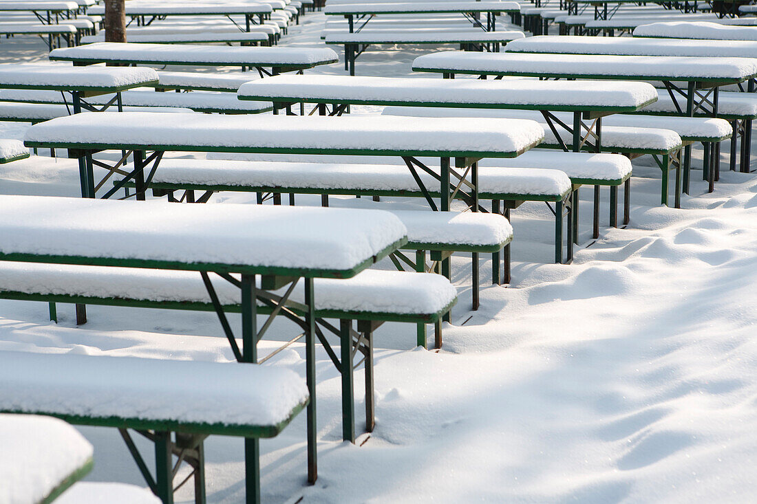 Snow-covered beer tables and benches in English Garden, Munich, Bavaria, Germany