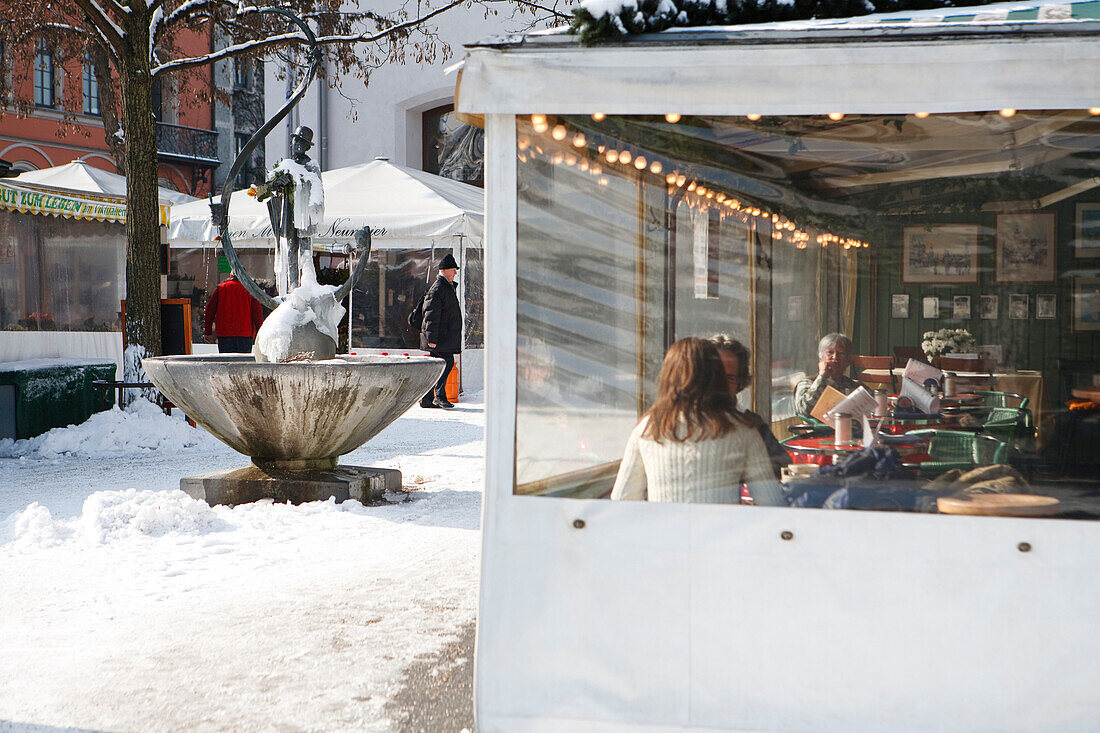 Restaurant and fountain of Karl Valentin at Viktualienmarkt in winter, Munich, Bavaria, Germany