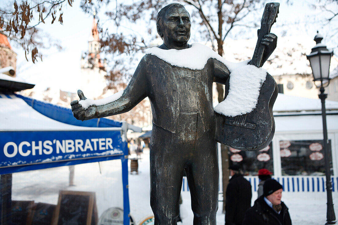 Snow-covered statue of Roider Jackl at Viktualienmarkt, Munich, Bavaria, Germany