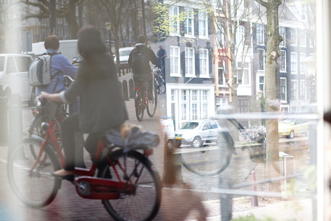 Traffic scene with bicycles reflected in a window, city of Amsterdam, Netherlands