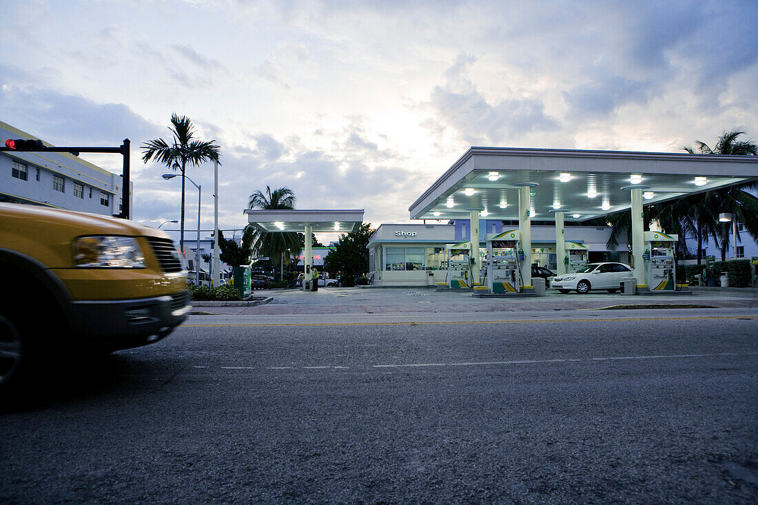 Taxi vor Tankstelle bei Abendlicht und dramatischem Himmel, Miami, Florida, USA