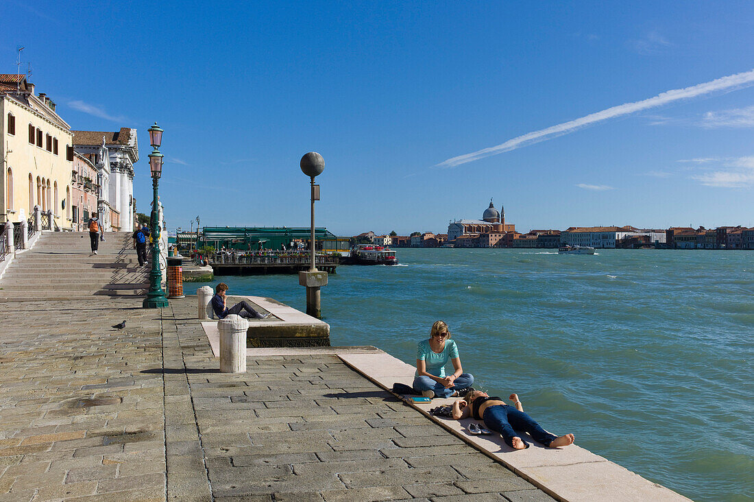 Menschen ruhen sich aus am Canale della Giudecca, Venedig, Venetien, Italien, Europa