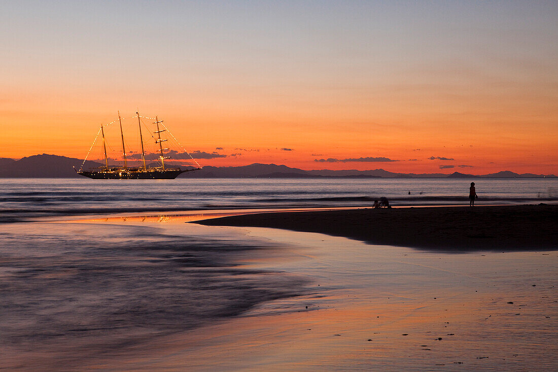 People on beach and sailing cruiseship Star Flyer (Star Clippers Cruises) at sunset, Puerto Caldera, Puntarenas, Costa Rica, Central America, America