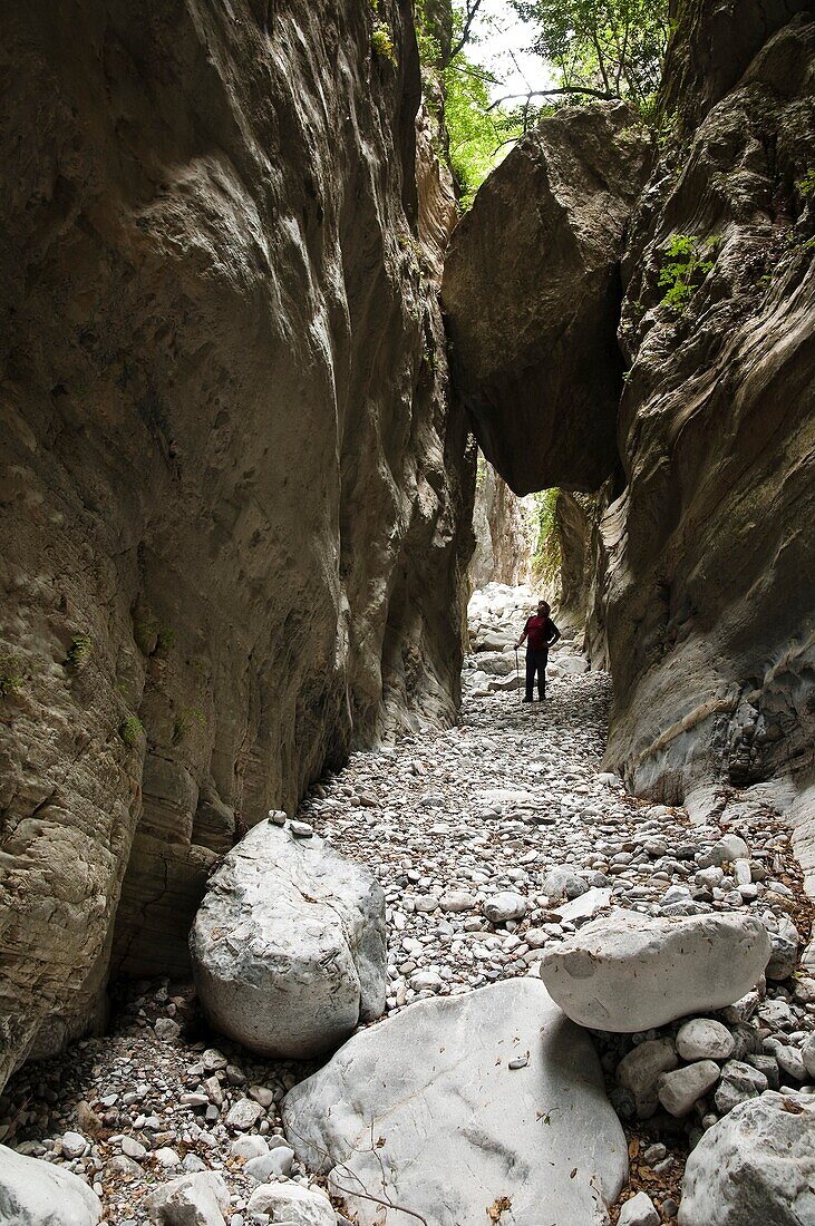 A walker at the narrowest point of the Ridomo Gorge In the Taygetos mountains, Outer Mani, Southern Peloponnese, Greece