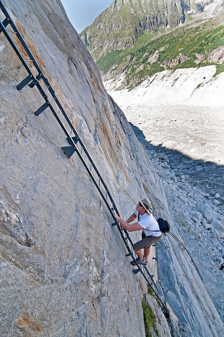 Elijah Weber climbs a steel ladder via ferrata on the Mer de Glace Glacier near Montenvers high above the city of Chamonix France
