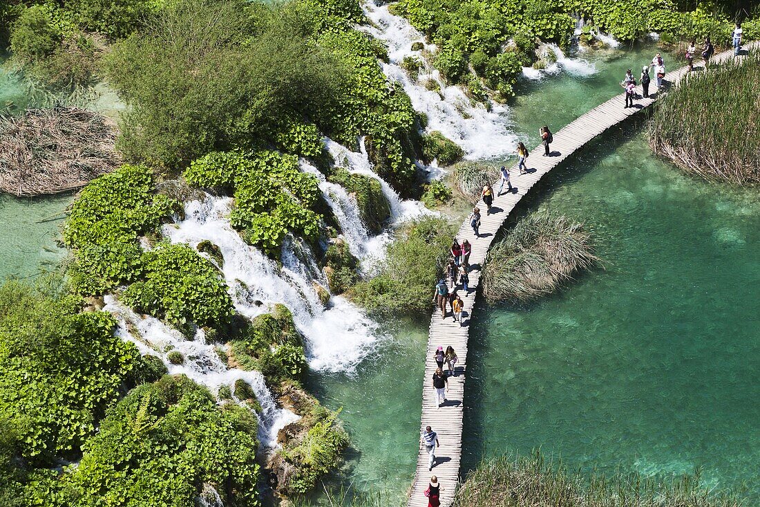 The Plitvice Lakes in the National Park Plitvicka Jezera in Croatia Visitors on the plank paths of the national Park The Plitvice Lakes are a string of lakes connected by waterfalls They are in a valley, which becomes a canyon in the lower parts of the