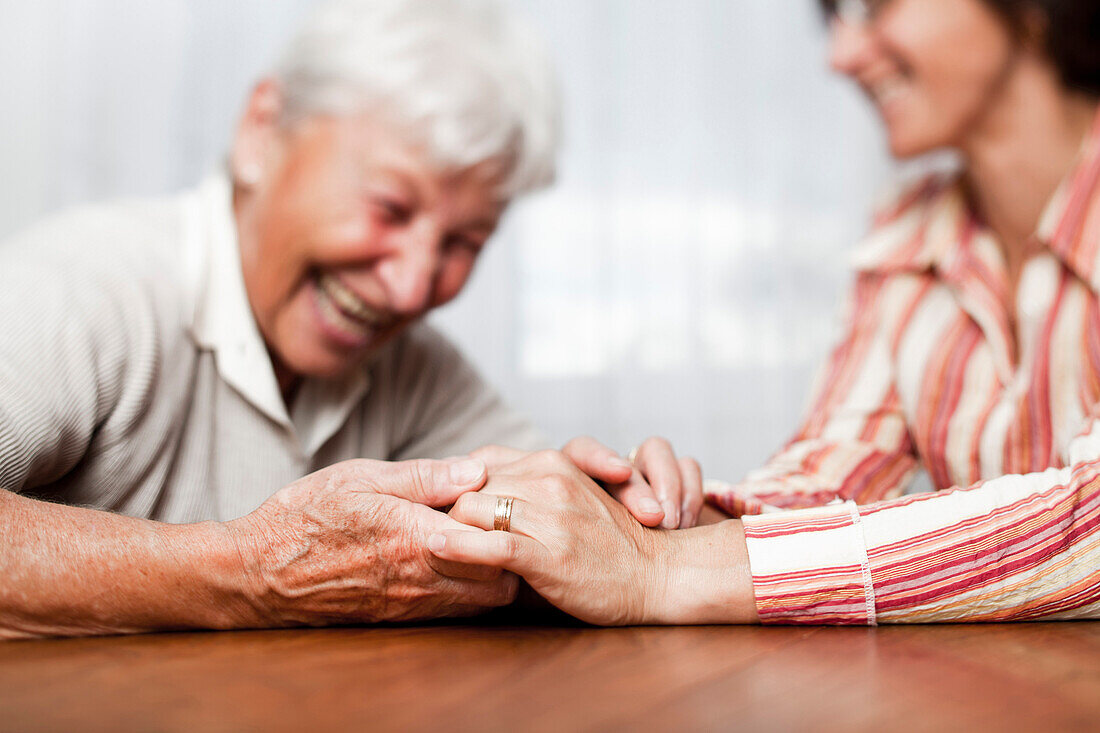 Eine alte und eine ältere Frau halten sich an den Händen, Zürich, Schweiz