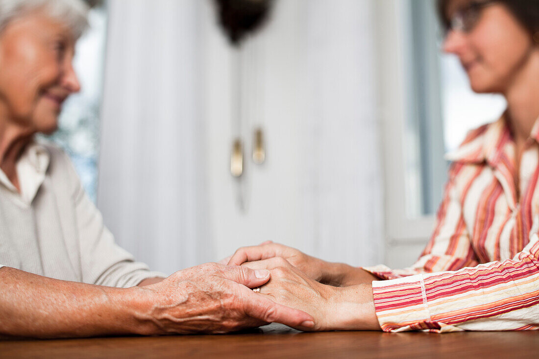 Eine alte und eine ältere Frau halten sich an den Händen, Zürich, Schweiz