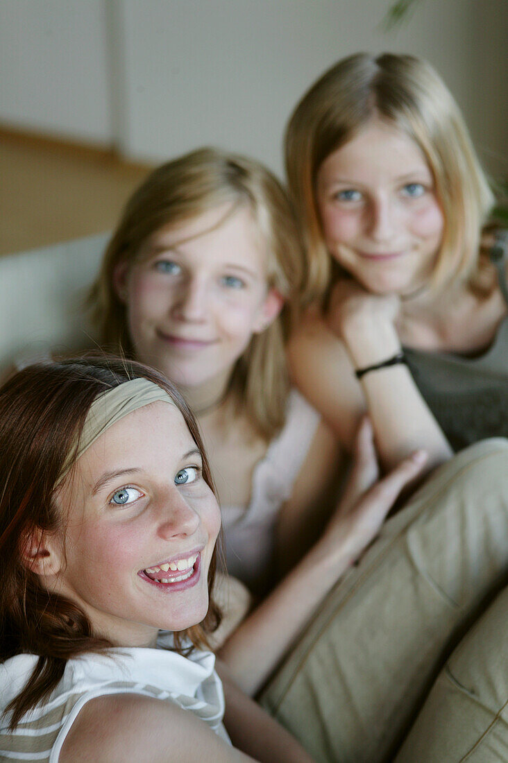 Drei Mädchen (12-15 years) lächeln in die Kamera
