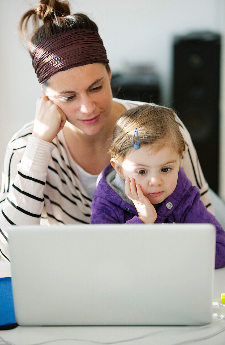 Woman and daughter (2 years) using a laptop, Vienna, Austria