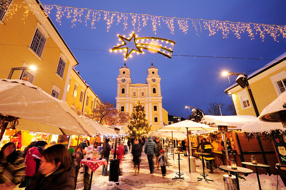 Christkindlmarkt Mondsee am Abend mit Kirche im Hintergrund, Mondsee, Salzburg, Österreich, Europa