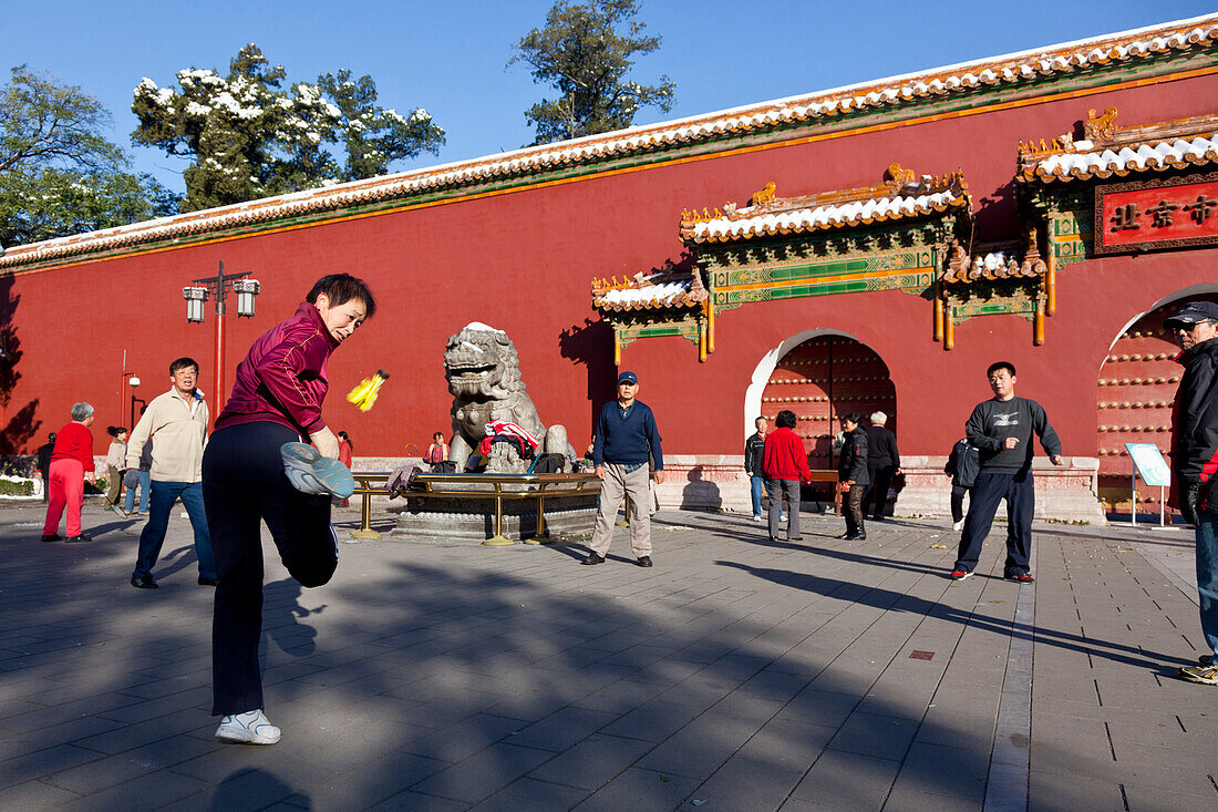 Morgensport im Jingshan Park am Nordtor, Gruppe spielen Federball mit dem Fuß, Körperertüchtigung, Peking, China