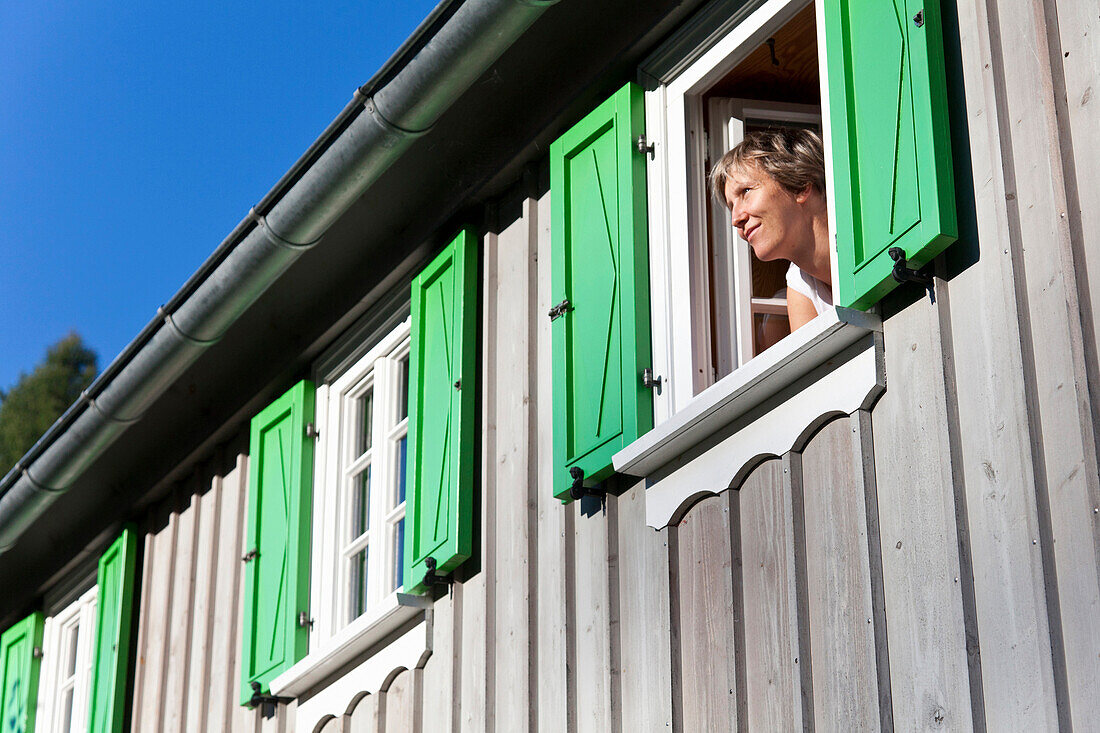 Frau blickt aus einem Fenster, Lückendorf, Oybin, Sachsen, Deutschland