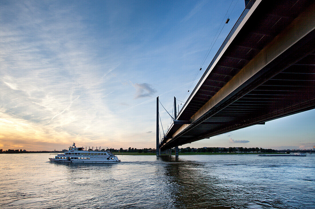 Schiff unter der Rheinkniebrücke bei Sonnenuntergang, Düsseldorf, Nordrhein-Westfalen, Deutschland, Europa