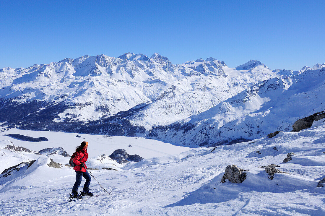 Frau auf Skitour blickt auf Berninagruppe und Silser See, Piz Grevasalvas, Albulaalpen, Oberengadin, Engadin, Graubünden, Schweiz, Europa
