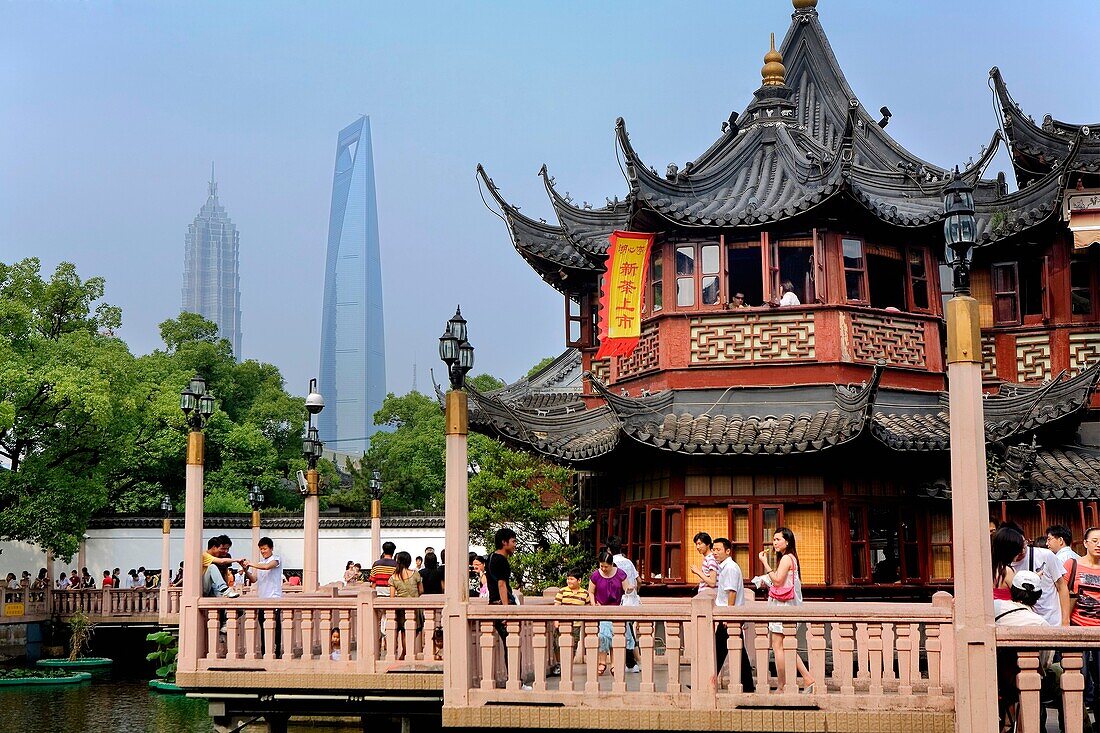 China Shanghai: Yu Yuan Bazar Zigzag bridge and Huxinting Tea House at right Pudong Skyline in Background with Jin Mao Building and Shanghai World Financial Center SWFC