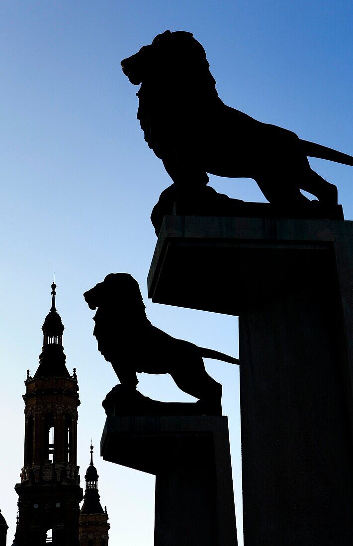 Zaragoza, Aragón, Spain: Lions at the entrance to bridgede piedra', with the towers of El Pilar