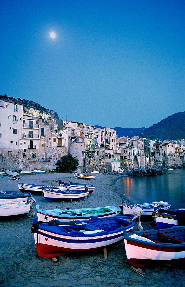 Cefalu, Sicily, Italy Full moon in summer evening sky over the fishing harbour of the town of Cefalu
