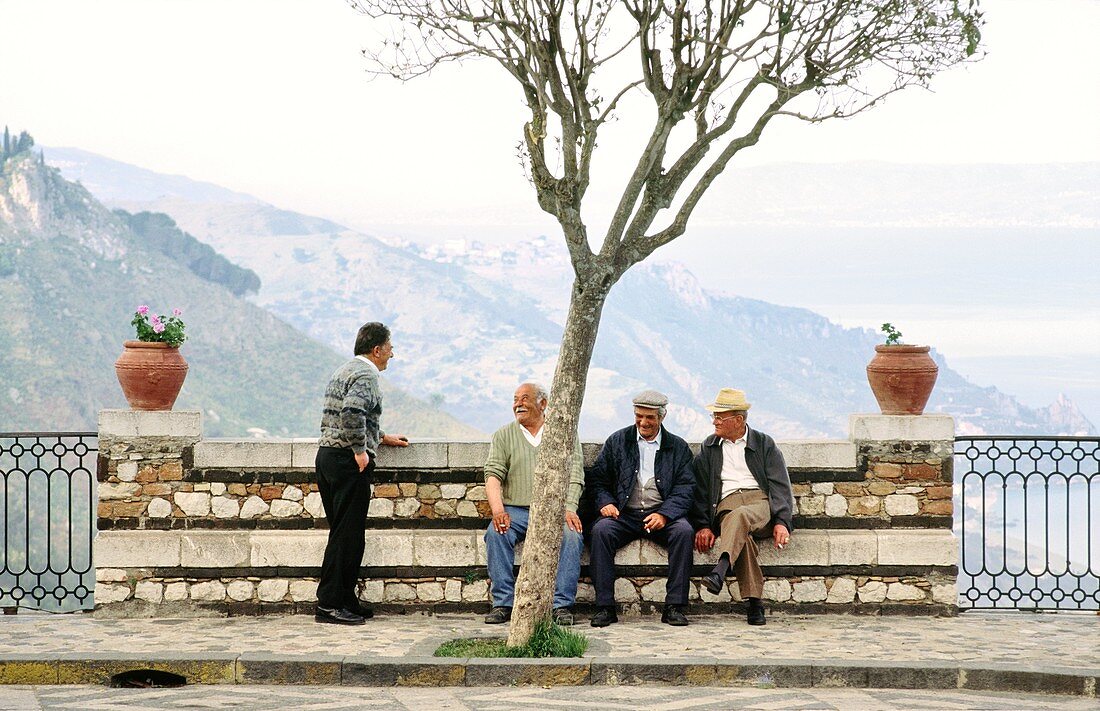 Sicily, Italy Men chatting in the square of the village of Castel Mola near Taormina