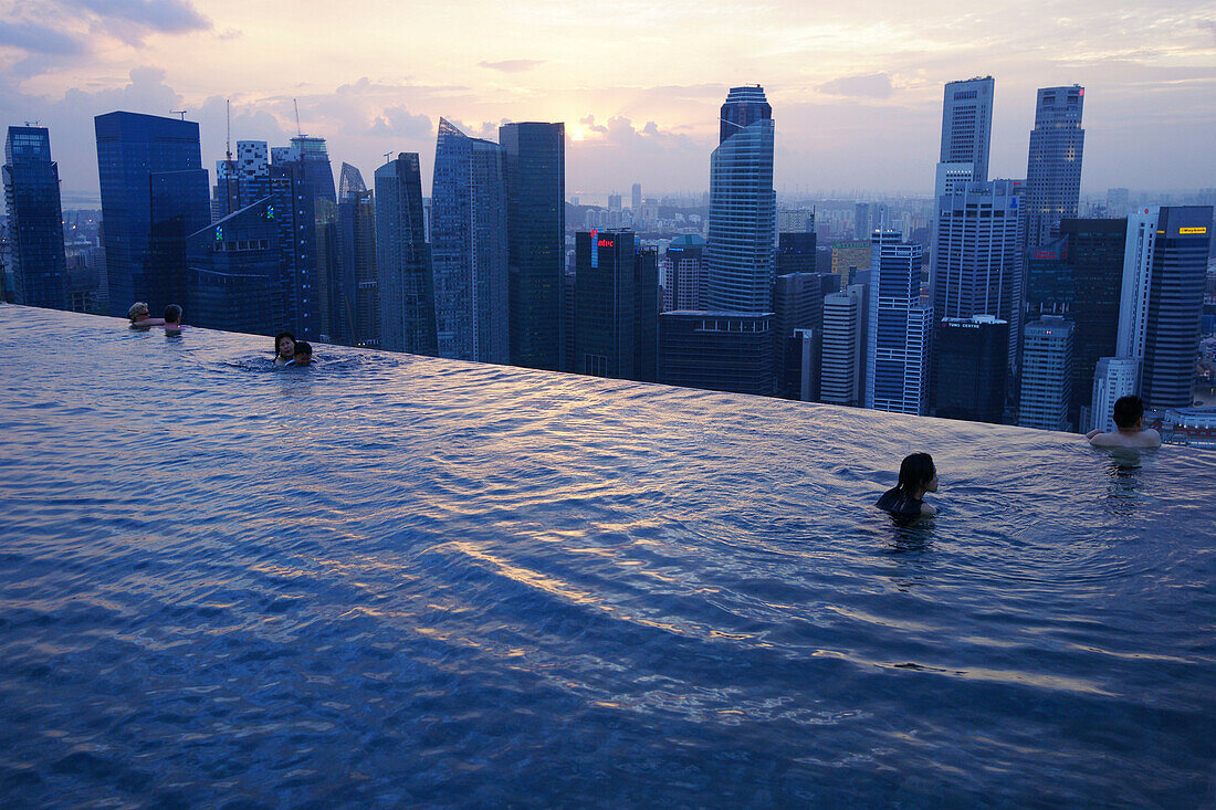 People swimming and admiring the view of the Central Business District from the Sands SkyPark Infinity Pool, Marina Bay Sands Hotel, Singapore, Asia