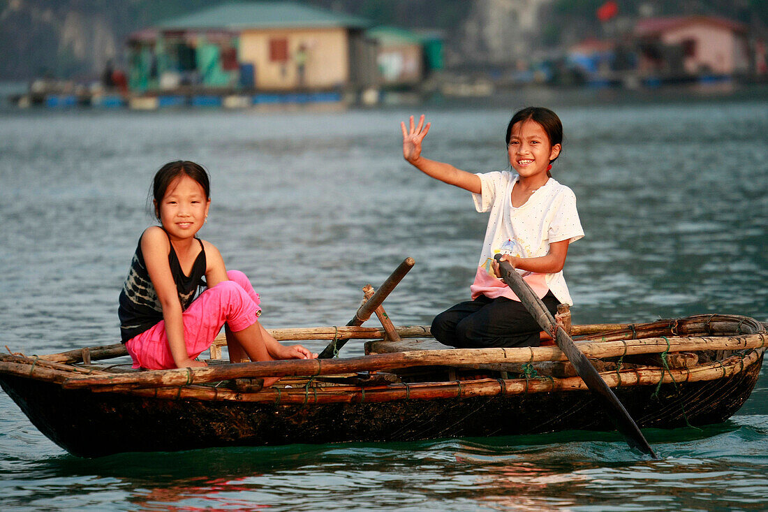 Local children in rowing boat, Ha Long Bay, Vietnam