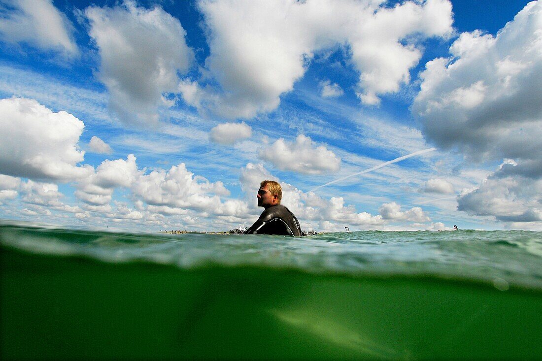 An unidentified surfer sits in his surfboard while he waits for a wave on a warm-up session during the Quiksilver Pro France, which is a part of the Foster's ASP World Tour of Surfing, at Hossegor in the south west coast of France