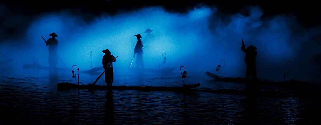 Chinese fishermen are silhouetted at night in the south province of Guangxi, China.