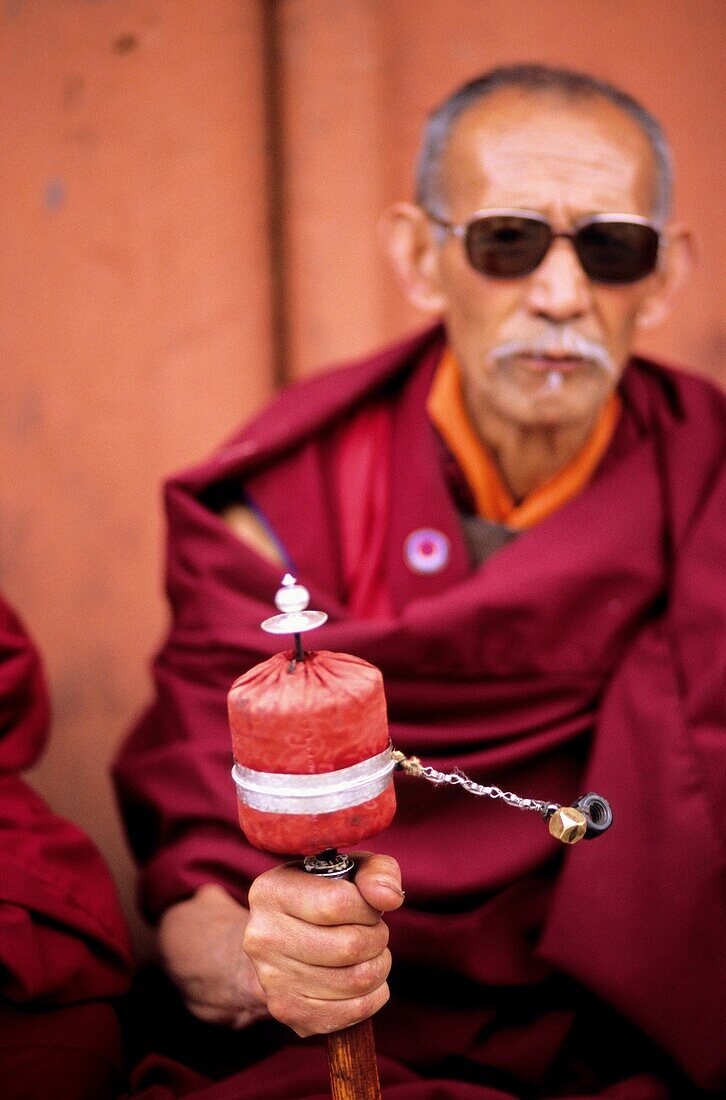 Tibetan monk praying with the traditional wheel, Ladakh, India