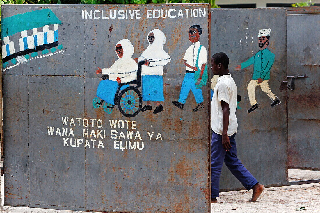 Kind geht durch das Tor zur Schule in Jambiani, Sansibar, Tansania, Afrika