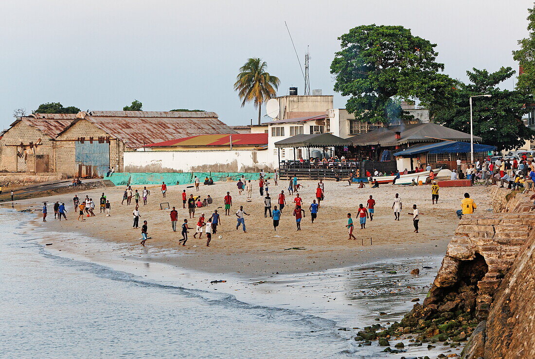 Kinder spielen Fussball am Strand vor Mercury's Restaurant, Stonetown, Sansibar City, Sansibar, Tansania, Afrika