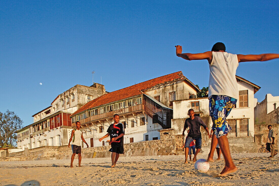 Kinder spielen Fussball am Stadtstrand von Stonetown, Sansibar City, Sansibar, Tansania, Afrika