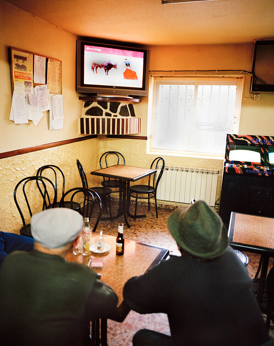 Two old men watching tv in one of the two bars in San Martin del Pimpollar, Sierra de Gredos, Castile and Leon, Spain