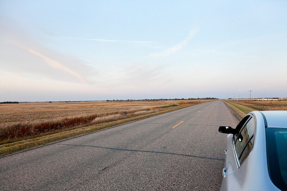 Parking car on a deserted road, fields, endless road, highway in the mid-west, Maxbass, Minot, North Dakota, United States of America, USA