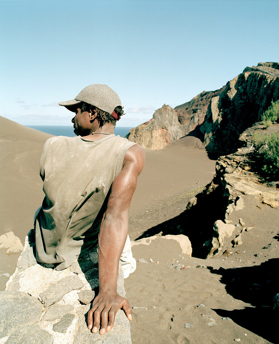 Labourer sitting on a wall, former village has been buried by a vulcanic eruption in 1958, Vulcao dos Capelinhos, Faial island, Azores, Portugal