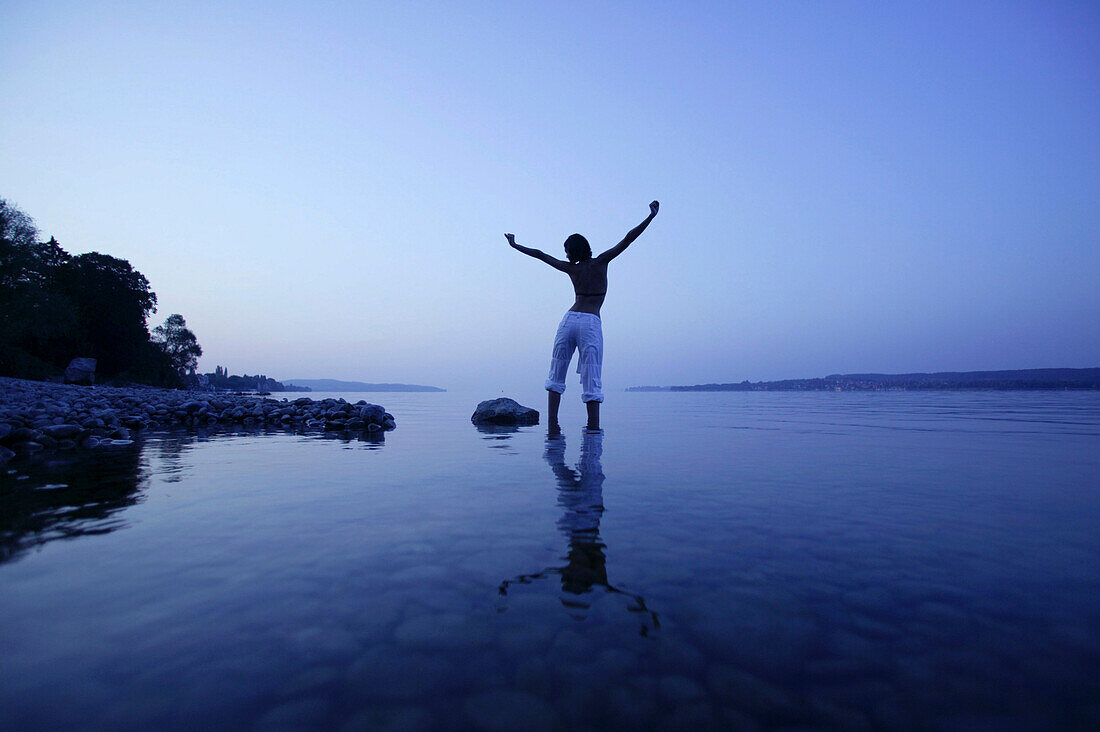 Young woman standing in shallow water, Lake Constance, Baden-Wurttemberg, Germany