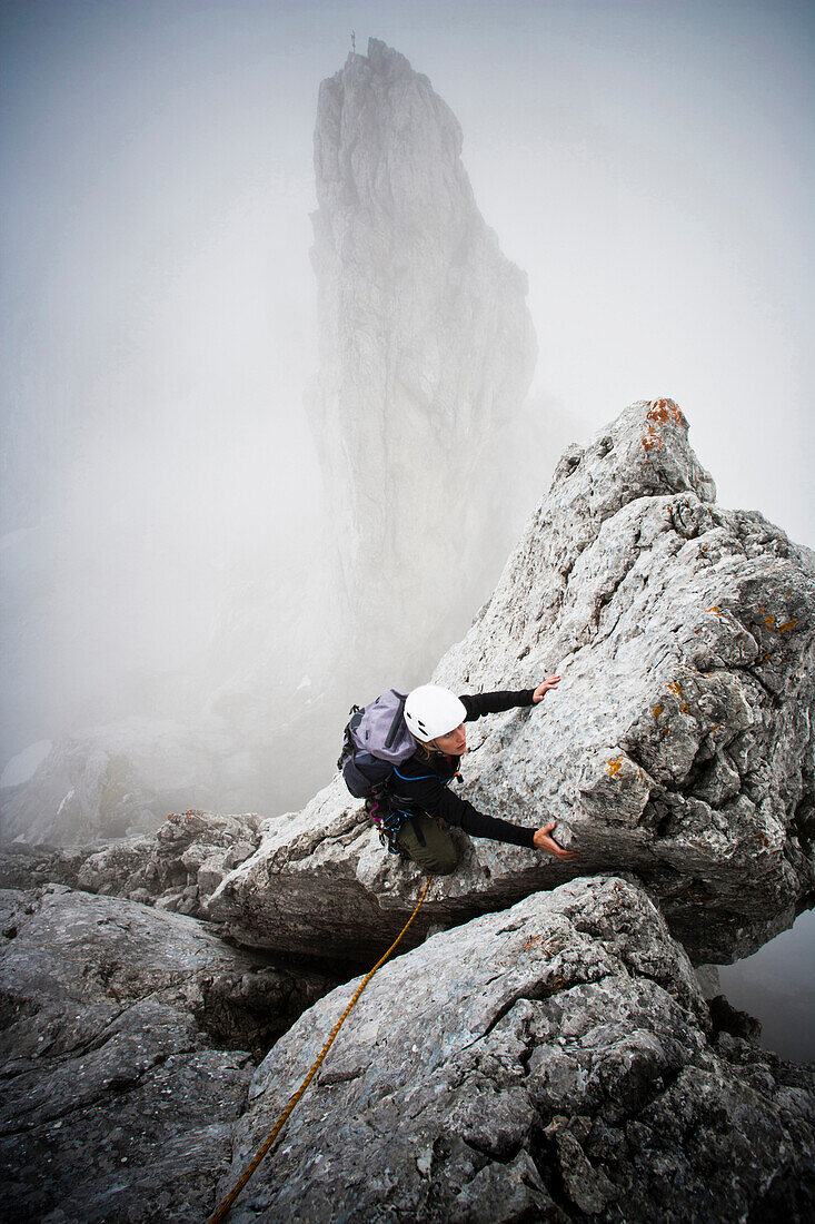 Female mountaineer at Kopftoerlgrat, Kapuzenturm in background, Ellmauer Halt, Kaiser Mountain Range, Tyrol, Austria