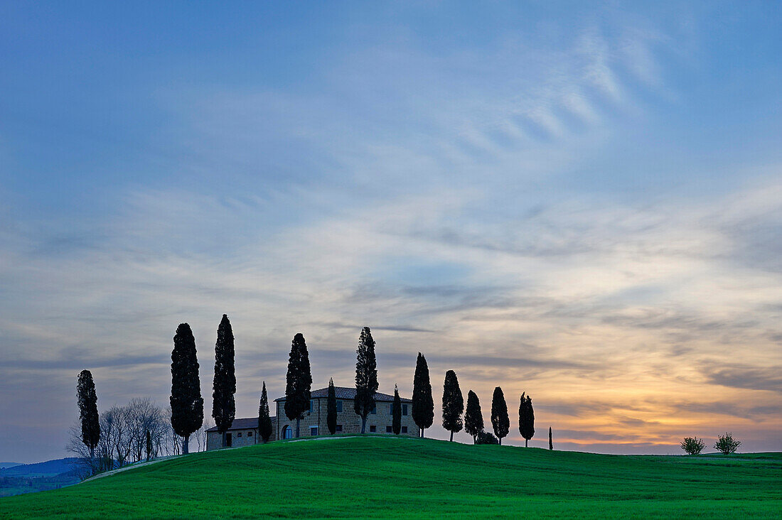 Landhaus zwischen Zypressen in der Morgendämmerung, Val d’Orcia, Toskana, Italien