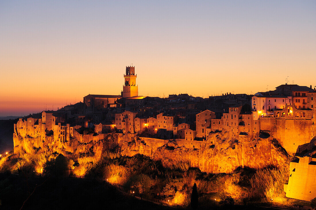 Beleuchtete Ortsansicht von Pitigliano in der Abenddämmerung, Pitigliano, Toskana, Italien