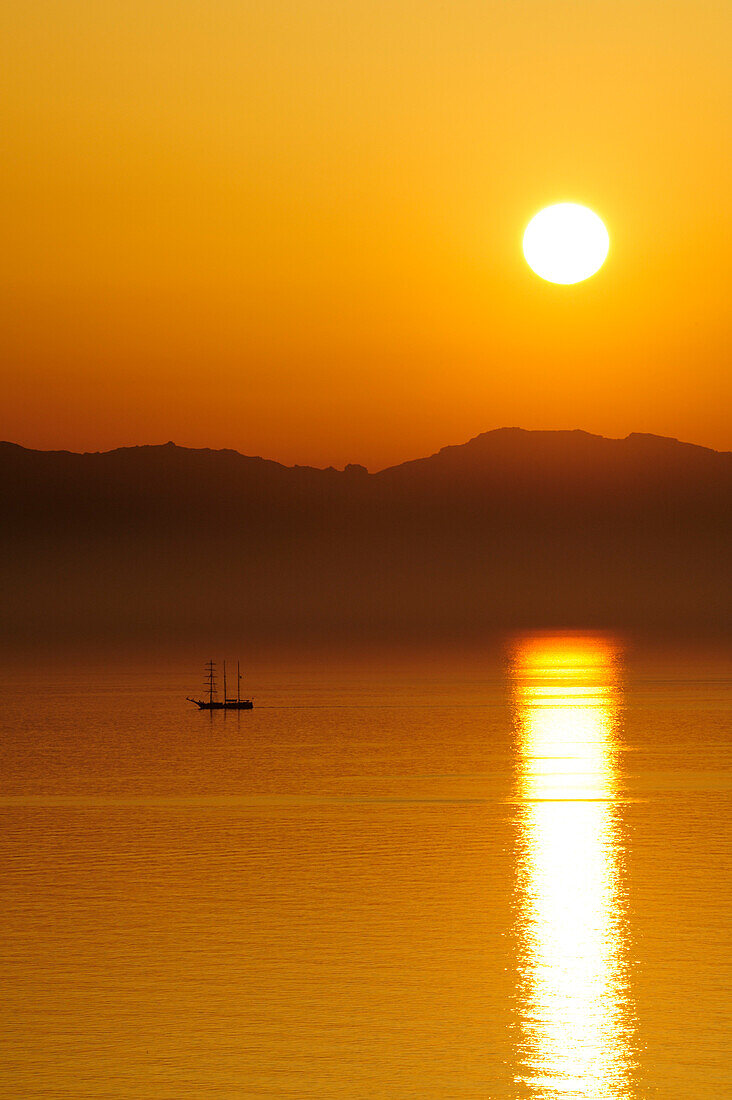 Segelschiff bei Sonnenuntergang im Mittelmeer, Insel Korsika im Hintergrund, Fetovaia, Insel Elba, Mittelmeer, Toskana, Italien