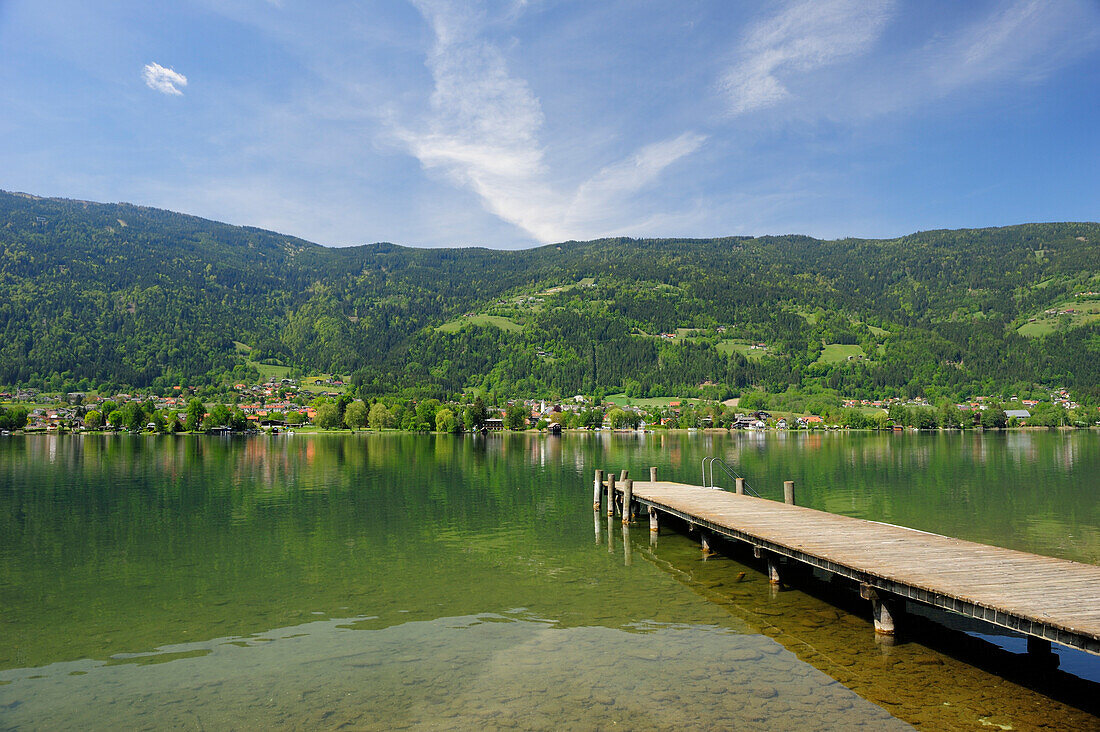 Holzsteg führt in Ossiacher See, Ossiach im Hintergrund, Ossiacher See, Kärnten, Österreich, Europa