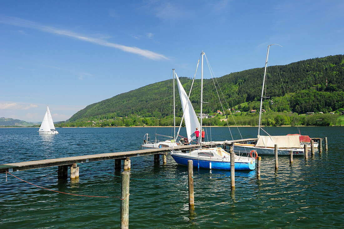 Wooden landing stage with sailing boats leading into lake Ossiacher See, Bodensdorf, lake Ossiacher See, Carinthia, Austria, Europe