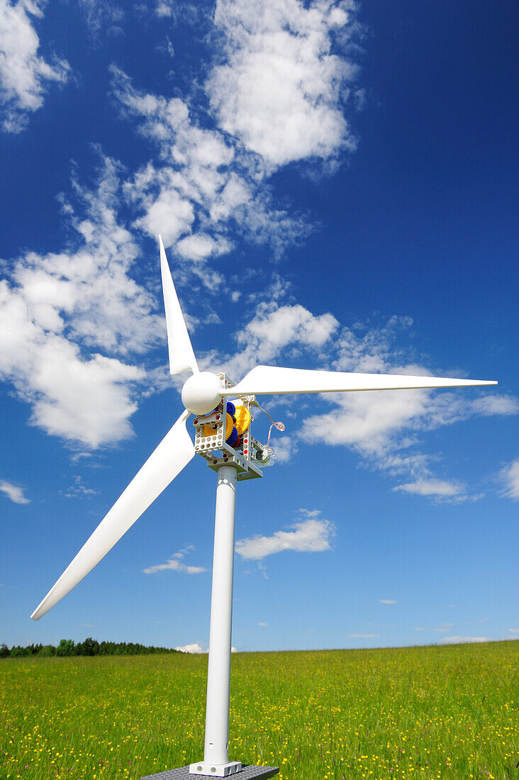 Modell von Windrad in grüner Wiese erzeugt Strom, Bayern, Deutschland, Europa