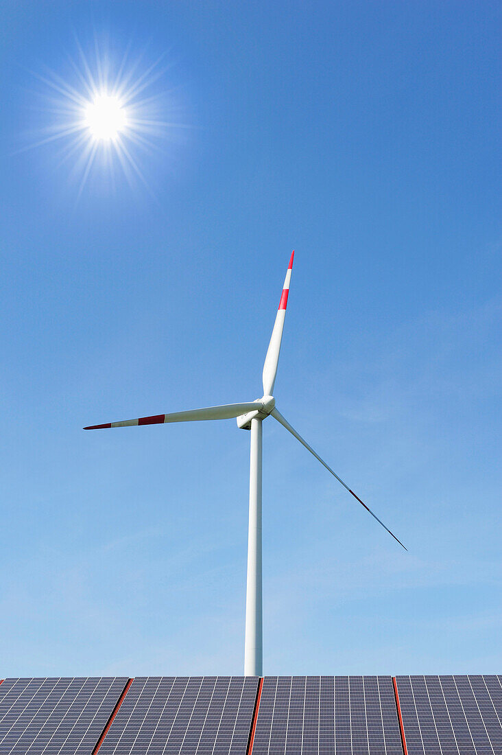 Wind power plant rising above solar panels, Ulm, Baden-Wuerttemberg, Germany, Europe