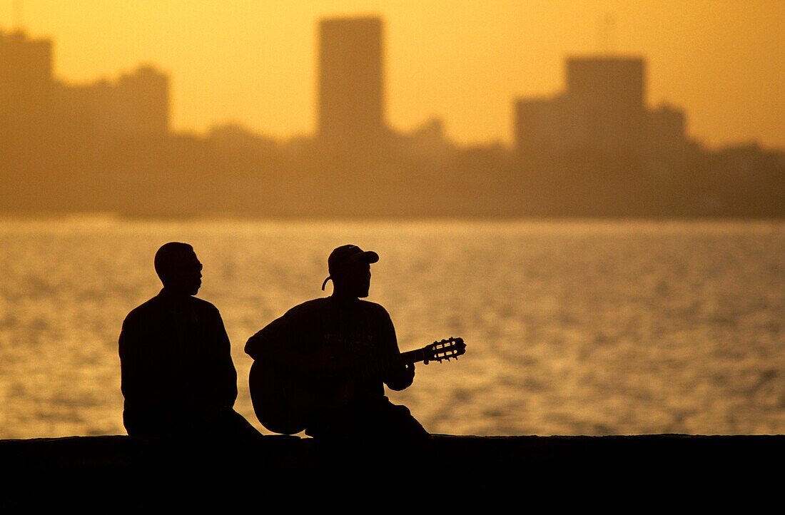 Local musician playing blues music at Goree island during sunset. Background, capital city Dakar. Senegal, West Africa