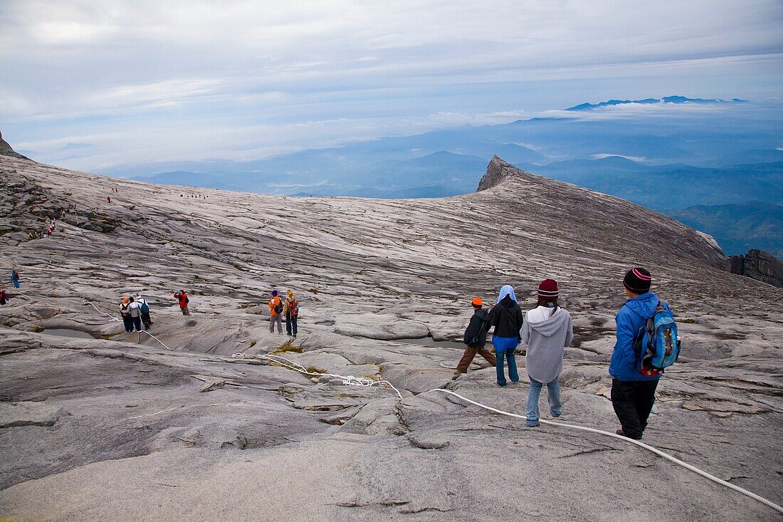 Sabah Malaysia, Borneo, Kinabalu National Park Hikers descend the summit trail through the dramatic landscape of Mount Kinabalu - The highest mountain peak in South East Asia