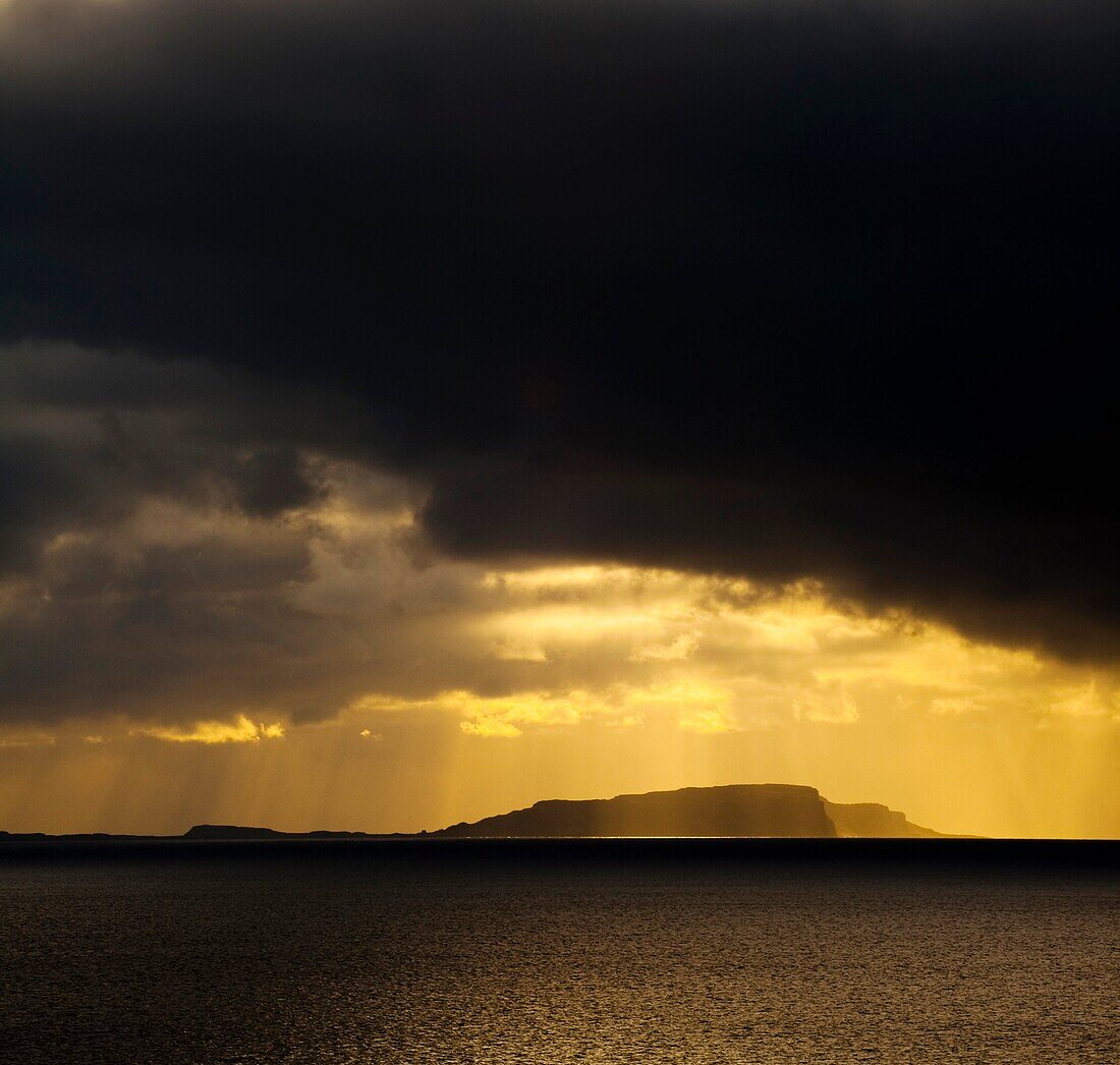 Scotland, Western Isles, Isle of Soay Dramatic shafts of light from the settin sun above the Isle of Soay, viewed from Elgol on the Isle of Skye