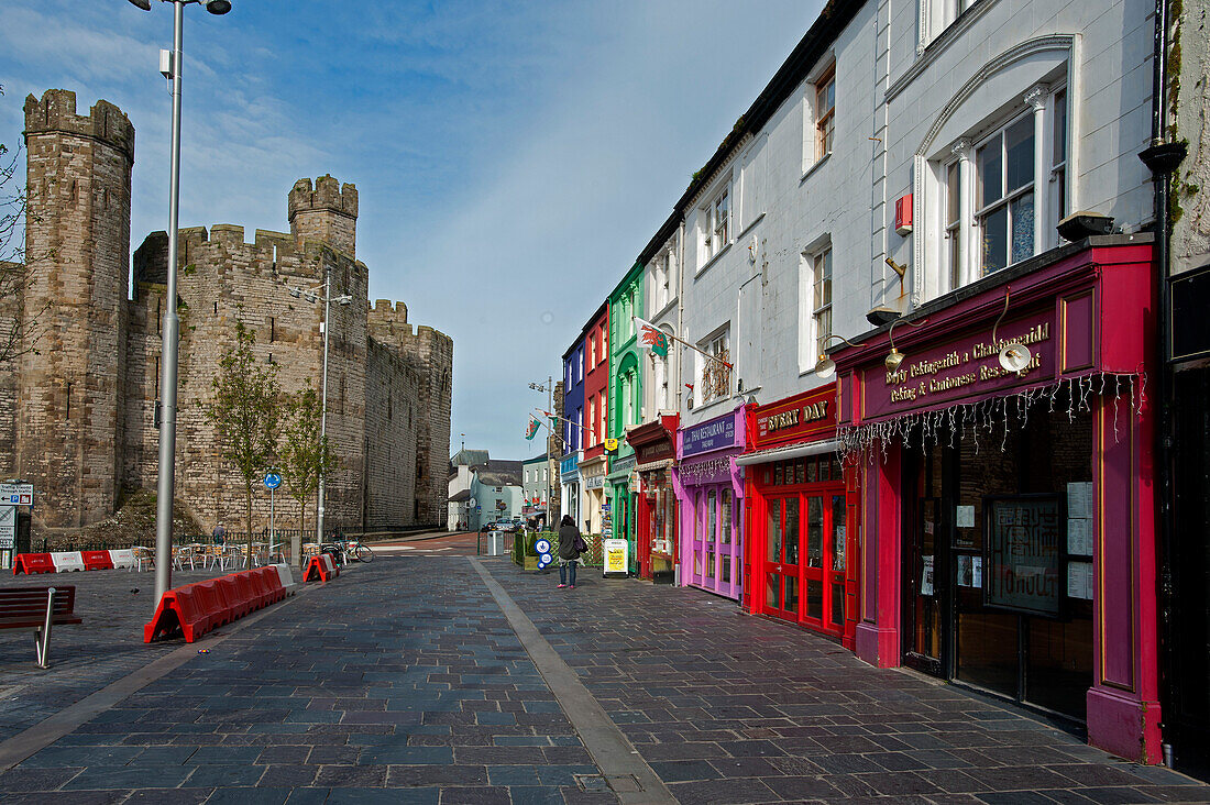 Caernarfon Castle with shops and restaurants, Caernarfon, Wales, UK