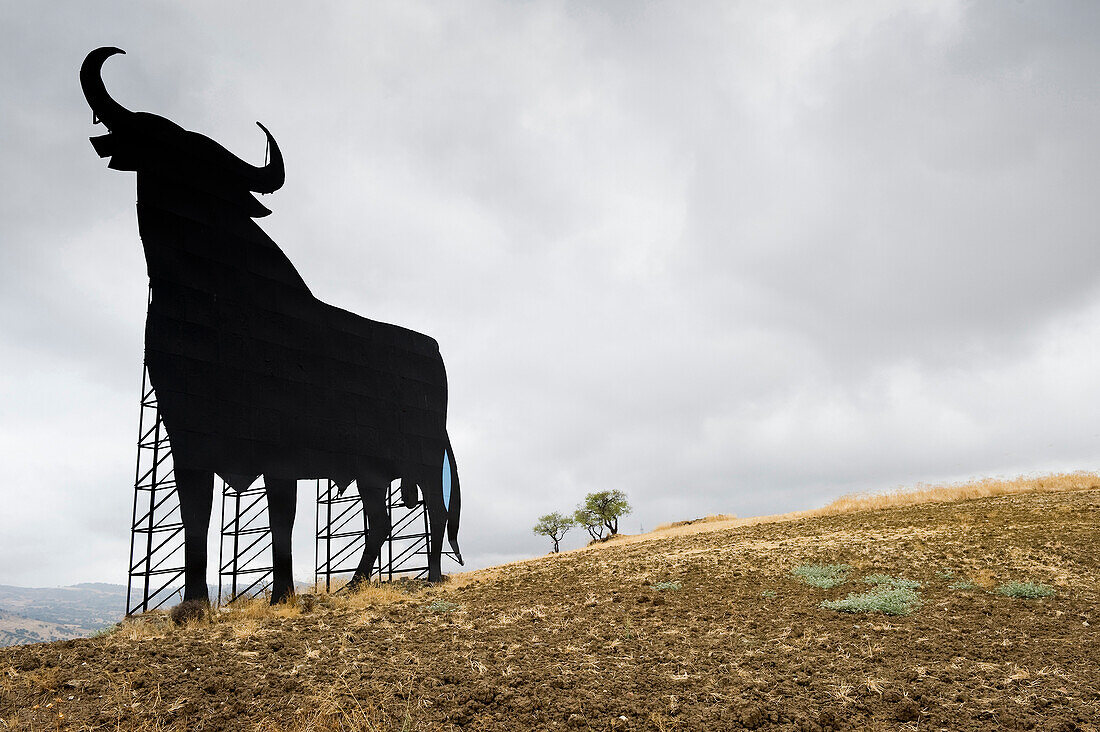 Osborne bull under clouded sky, Andalusia, Spain, Europe