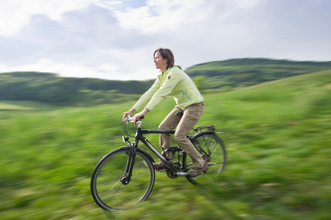 Radfahrerin auf einer Wiese, Schwarzwald, Baden-Württemberg, Deutschland, Europa